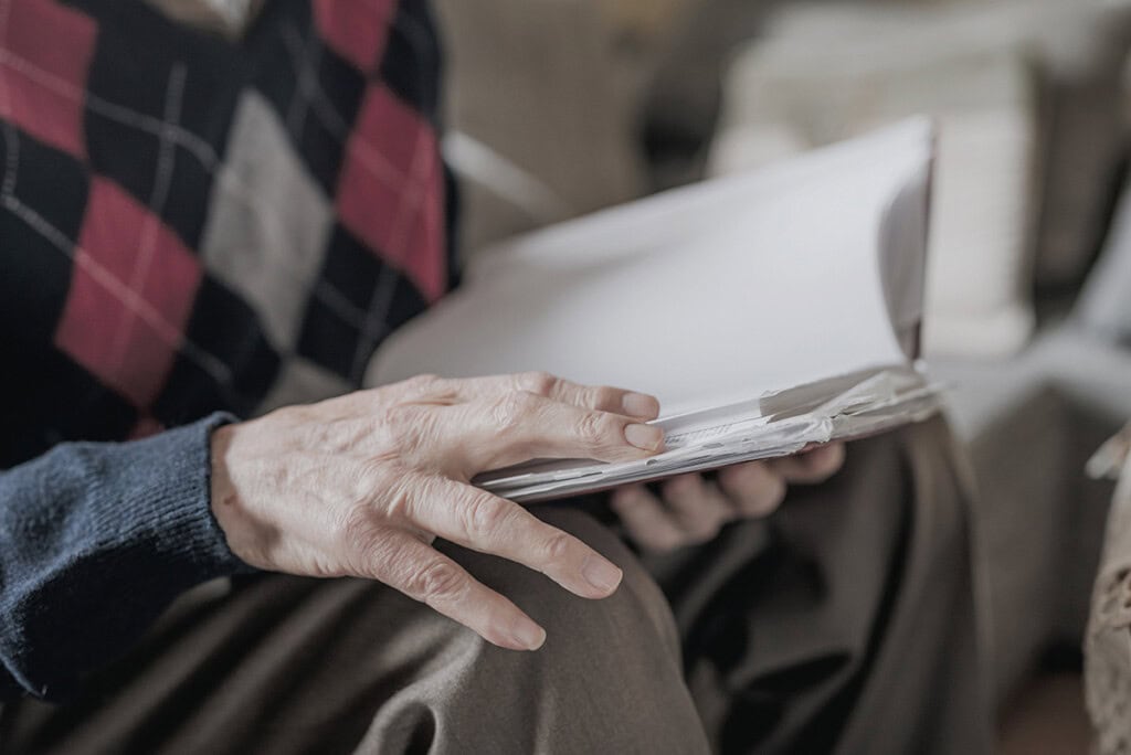 Elderly man reading book at home